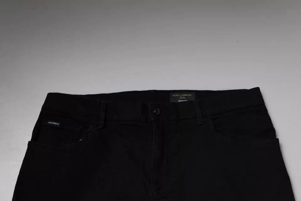 Jeans skinny en denim coton stretch noir Dolce & Gabbana avec logo, visibles sur l'image.