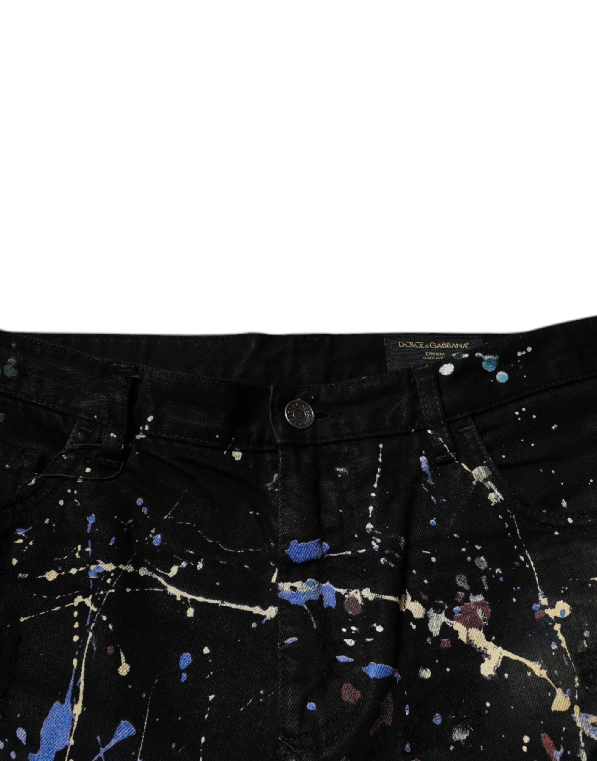 Jeans skinny en coton noir avec éclaboussures de couleur, de la marque Dolce & Gabbana, visibles en détail.