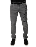 Jeans skinny en denim coton gris avec impression graphique Dolce & Gabbana, visible avec détails de design moderne.