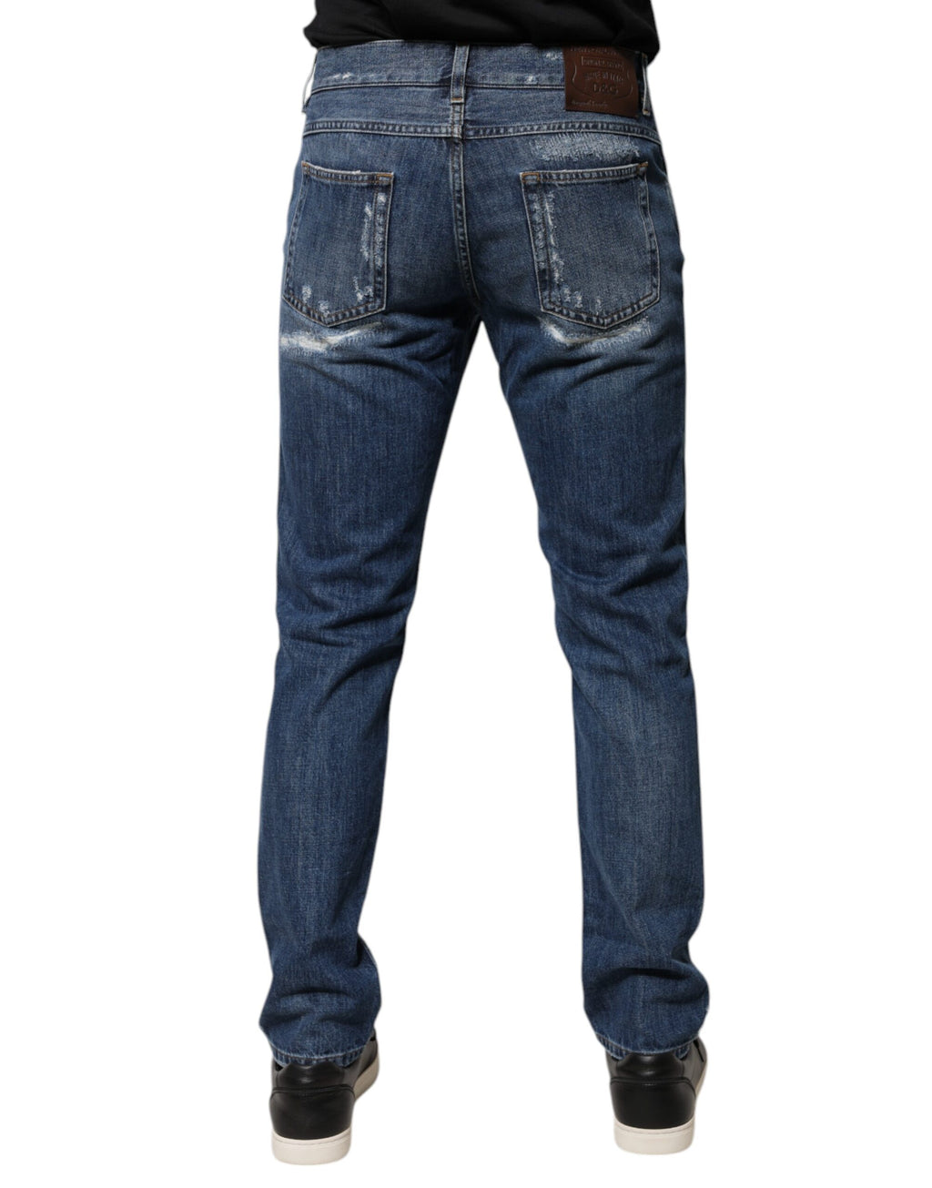 Jeans skinny en denim bleu en coton Dolce & Gabbana avec déchirures et coupe tachetée, visible sur l’image.