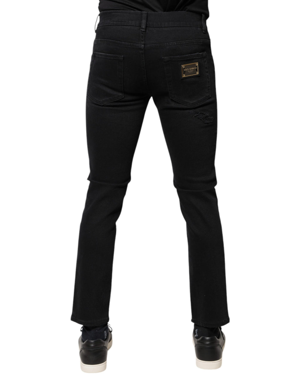 Jeans skinny en denim noir Dolce & Gabbana en coton déchiré avec logo, visibles sur le produit.
