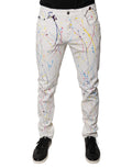 Jeans skinny en denim blanc avec motif éclaboussure de couleurs Dolce & Gabbana, style moderne et tendance.