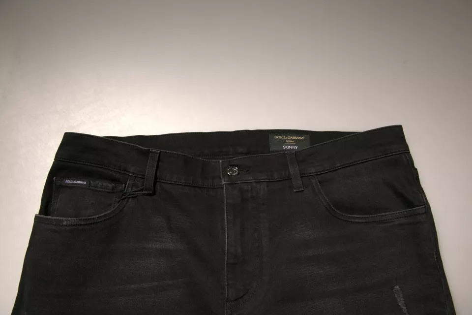 Jeans skinny en denim noir Dolce & Gabbana avec déchirures et logo brodé, coupe ajustée et style tendance.
