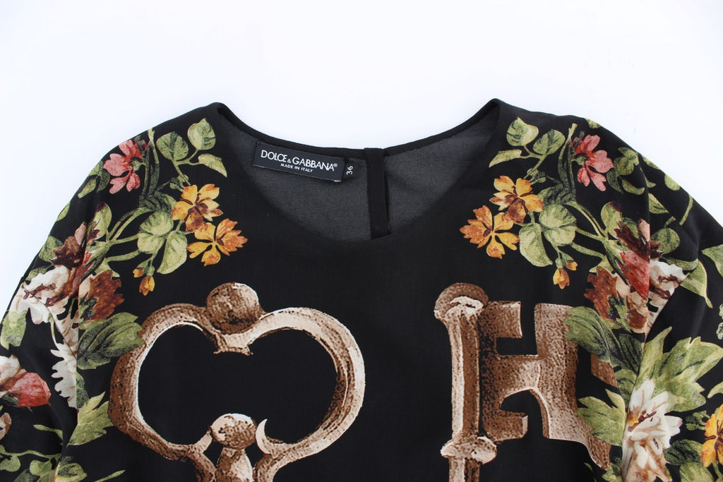 Blouse en soie noire à imprimé floral clé par Dolce & Gabbana, haut élégant avec détails raffinés.