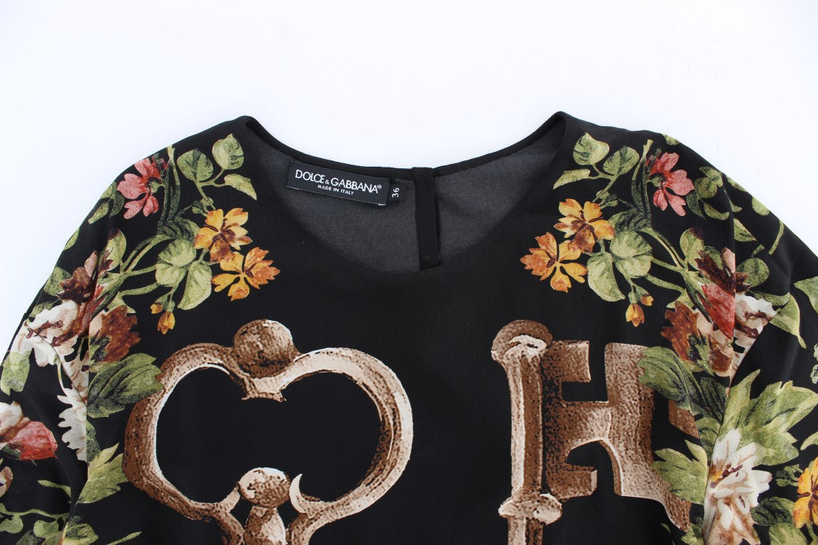 Blouse en soie noire à imprimé floral clé par Dolce & Gabbana, haut élégant avec détails raffinés.