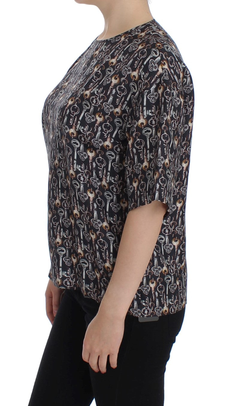 Blouse en soie gris et or Dolce & Gabbana avec motif clé, élégante et sophistiquée, portée sur un mannequin.