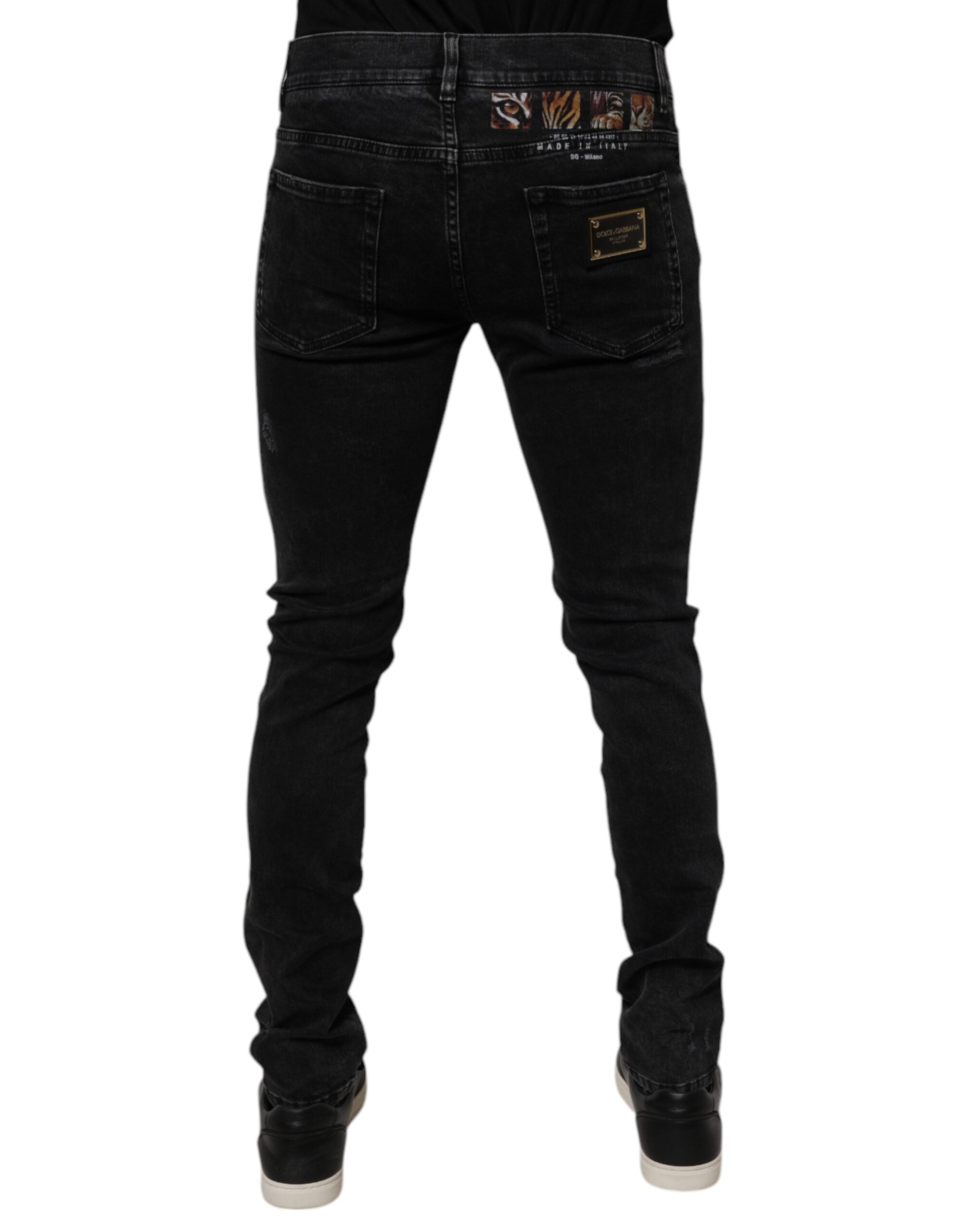 Jeans homme Dolce & Gabbana en denim noir déchiré, coupe skinny, en coton avec détails usés.