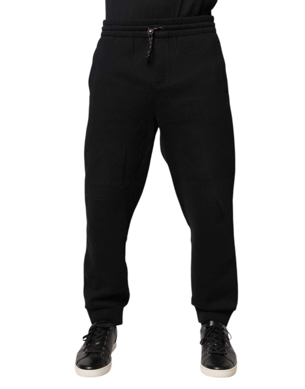 Pantalon jogger en coton noir Dolce & Gabbana avec patch logo, style décontracté et élégant, visible en gros plan.