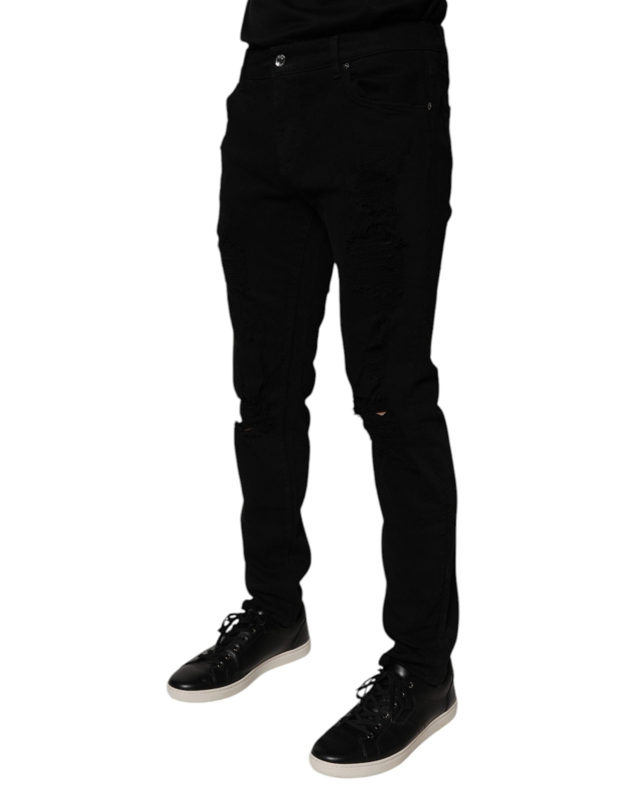 Jeans homme Dolce & Gabbana en denim noir déchiré, coupe skinny, en coton avec détails usés.
