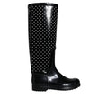 Bottes de pluie en caoutchouc noir de Dolce & Gabbana, style élégant et imperméable, visibles dans l'image.