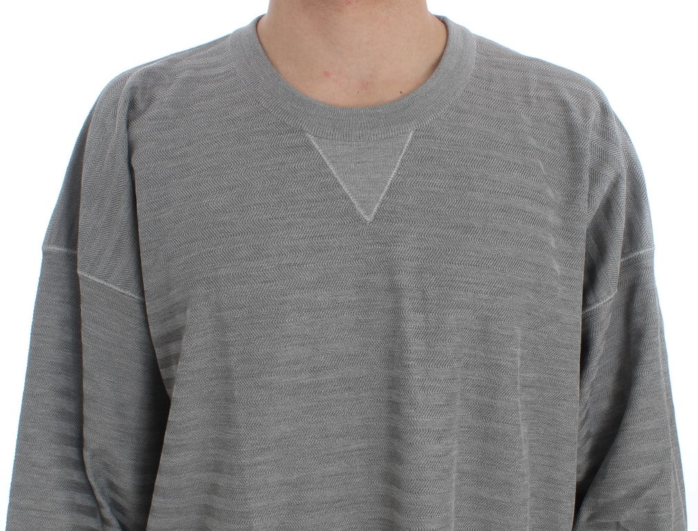 Pull en soie gris Dolce & Gabbana avec col rond, visible sur une mannequin portant le pull dans une présentation élégante.