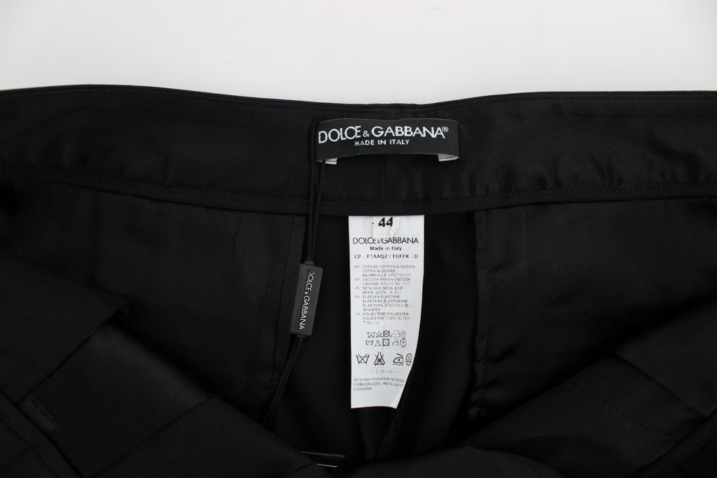 Pantalons capri Dolce & Gabbana en coton stretch noir avec motif torero, ajustés et élégants, visibles en gros plan.
