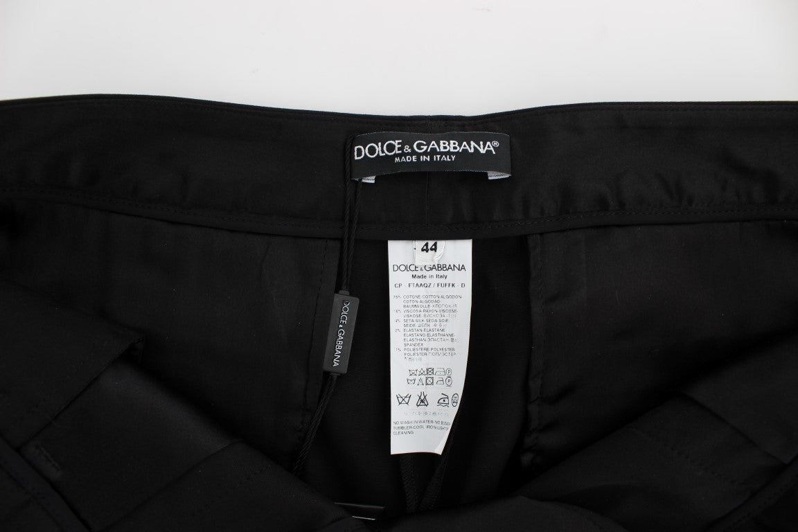Pantalons capri Dolce & Gabbana en coton stretch noir avec motif torero, ajustés et élégants, visibles en gros plan.