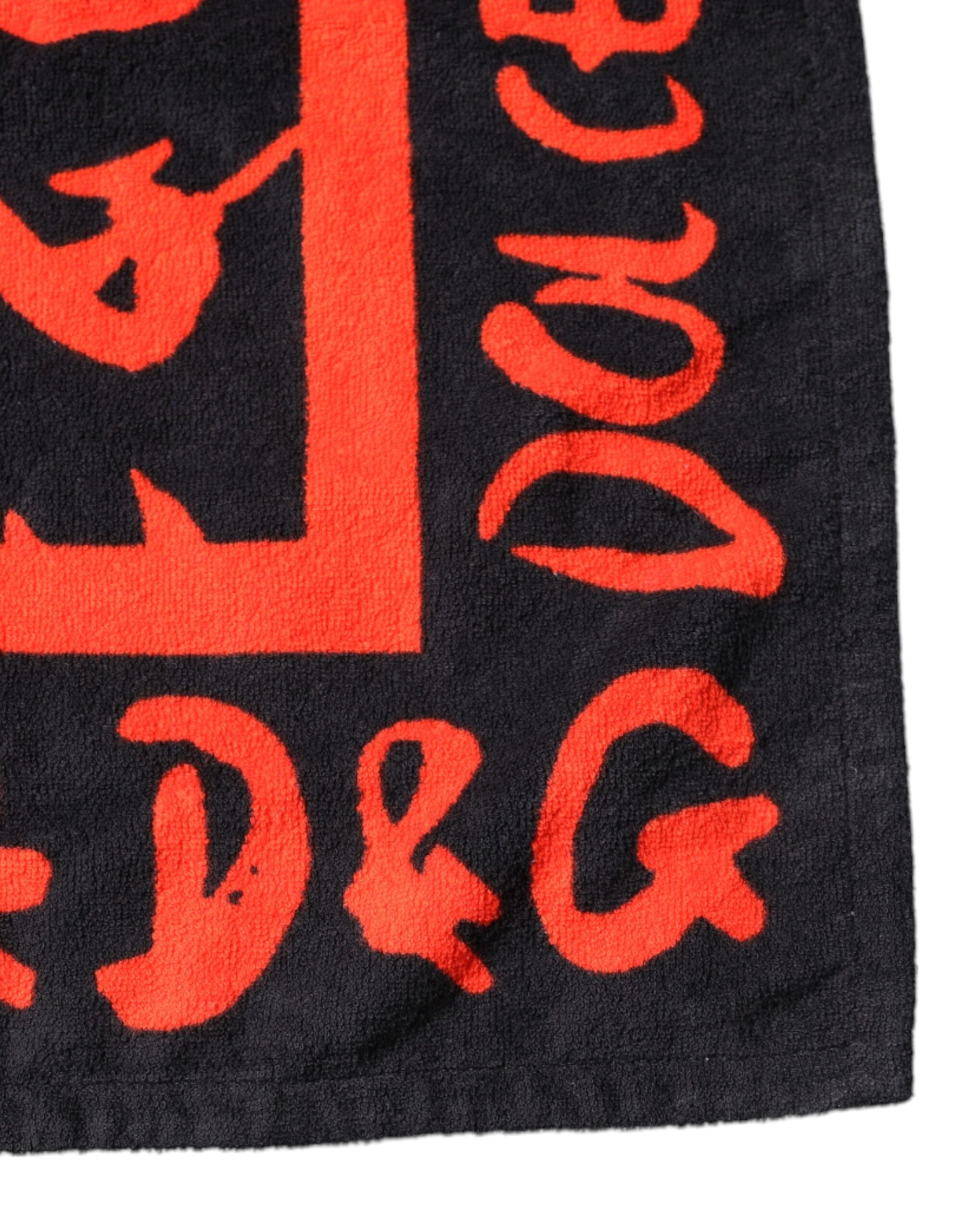 Serviette de plage en coton noir et rouge avec logo Dolce & Gabbana, motif imprimé, vue de face.