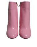 Bottes mi-mollet en cuir verni rose Dolce & Gabbana avec talons, vue de face.