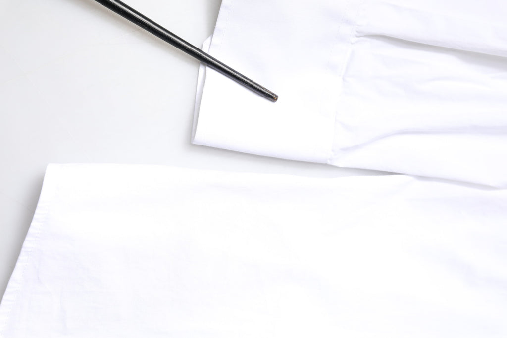 Chemise homme Dolce & Gabbana en coton blanc à manches longues avec détails dorés, élégante et sophistiquée.