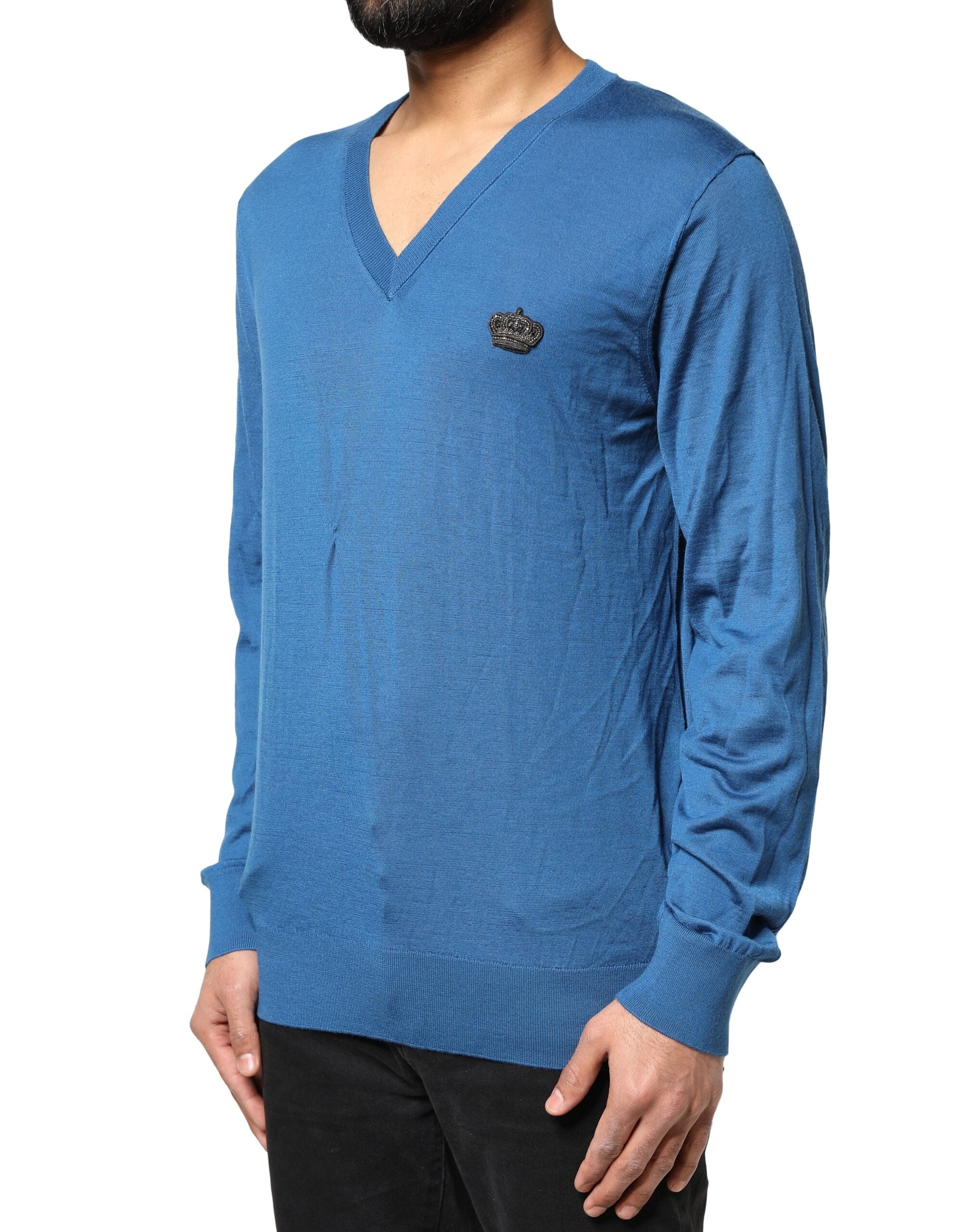 Pull en cachemire bleu Dolce & Gabbana avec col en V et motif couronne, élégant et confortable, porté sur un mannequin.