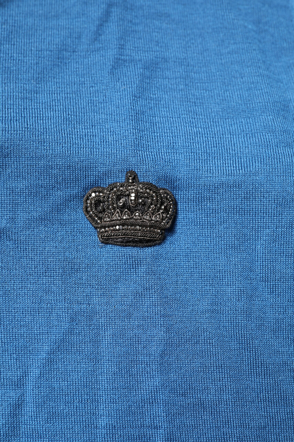 Pull en cachemire bleu Dolce & Gabbana avec col en V et motif de couronne, parfait pour un look élégant et confortable.