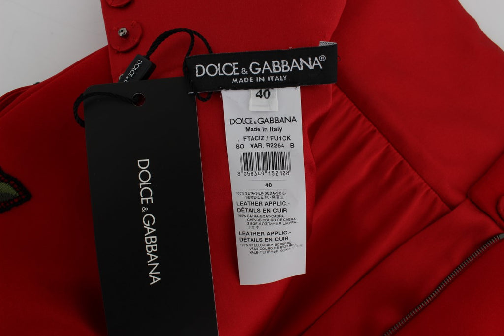 Shorts en soie rouge de Dolce & Gabbana avec roses en cristal, style élégant et luxueux.