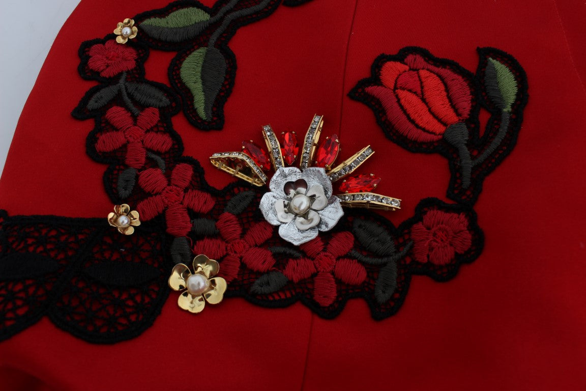 Shorts en soie rouge Dolce & Gabbana ornés de roses en cristal, élégants et sophistiqués, visibles en détail dans cette image.