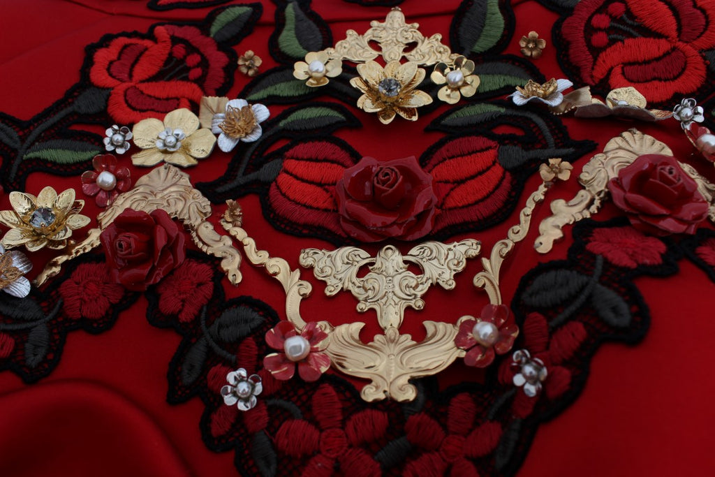 Shorts en soie rouge Dolce & Gabbana ornés de roses en cristal, élégants et raffinés, visibles en détail sur l'image.