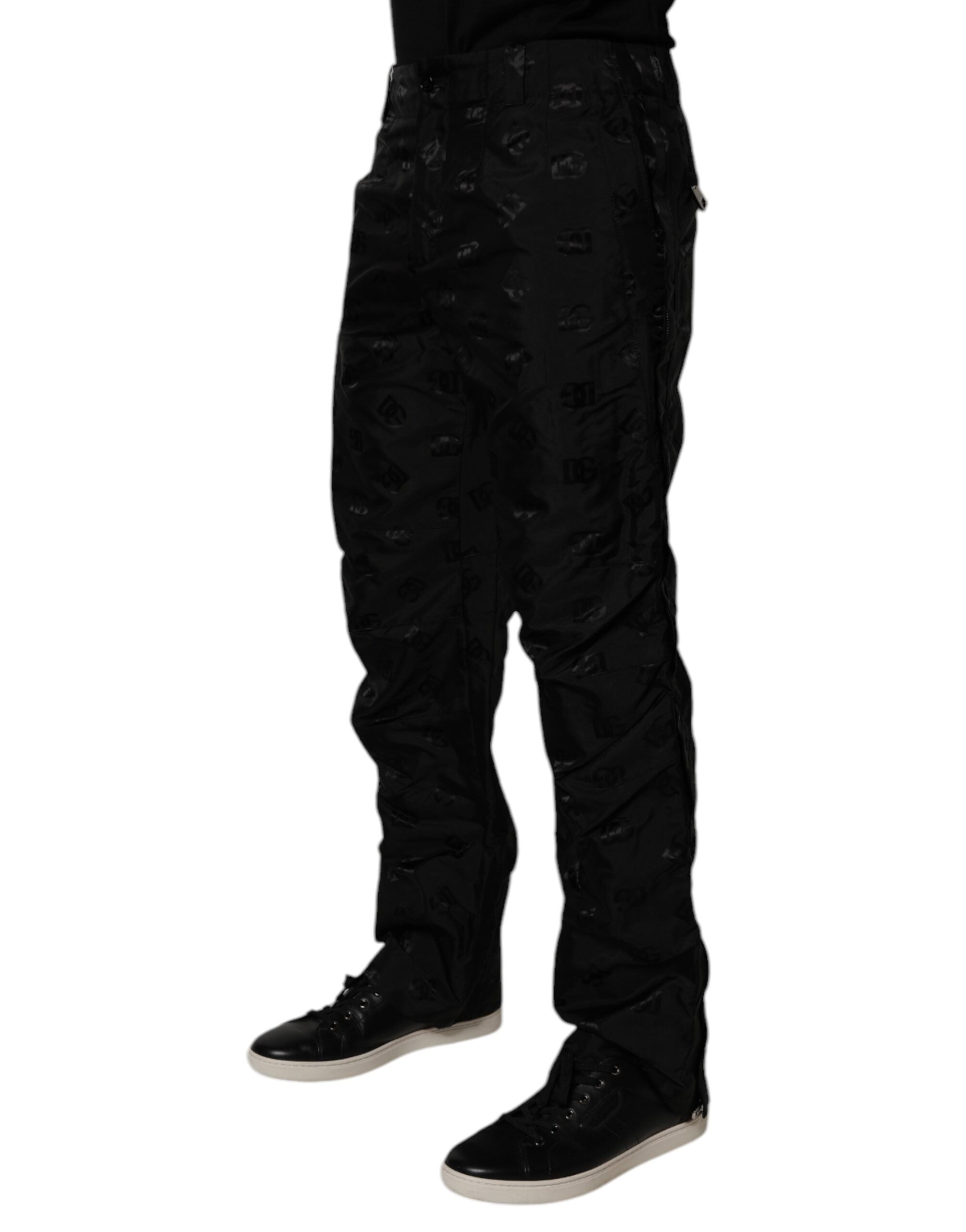 Pantalons droits noirs Dolce & Gabbana avec logo monogramme doré, en tissu élégant, visibles en détail sur l'image.