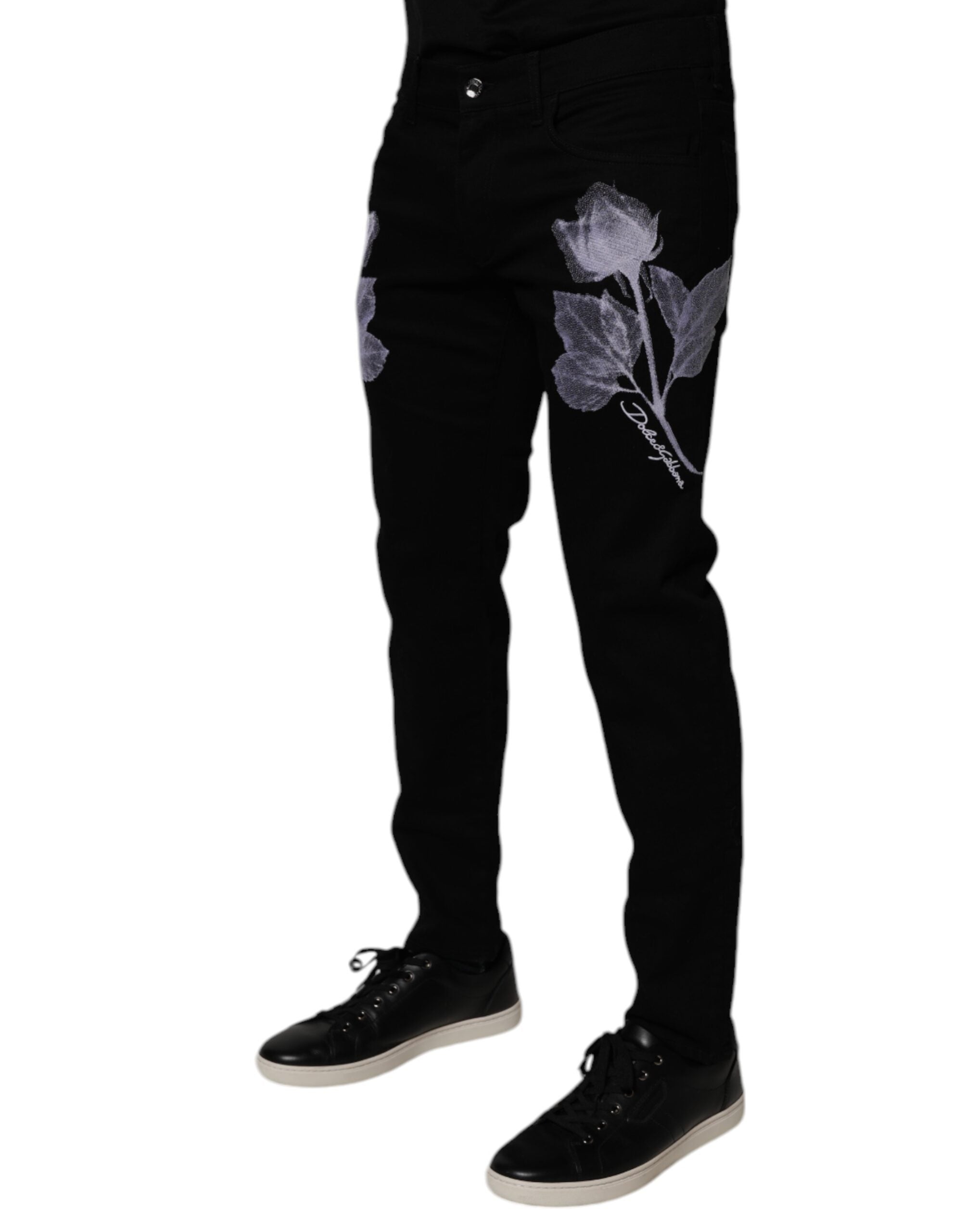 Jeans slim en coton noir à fleurs Dolce & Gabbana pour homme, style skinny avec détails floraux visibles.