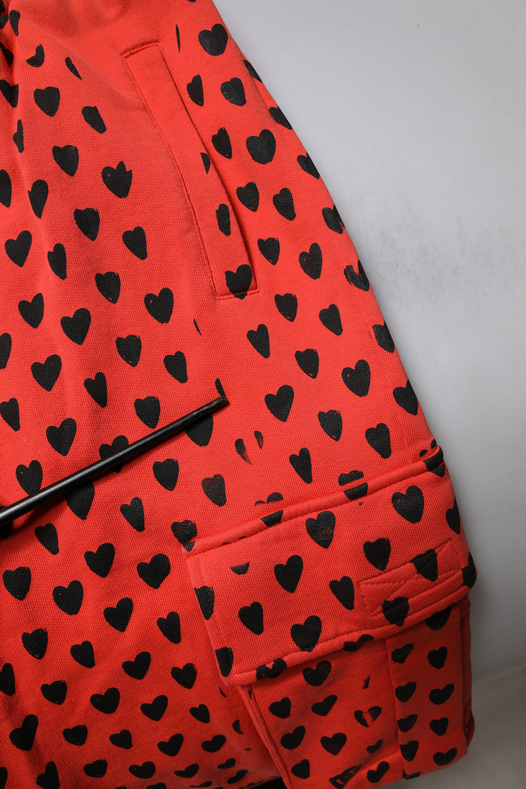 Pantalon cargo Dolce & Gabbana rouge à cœurs pour homme, jogger en sweatpants avec poches et motif cœur rouge.