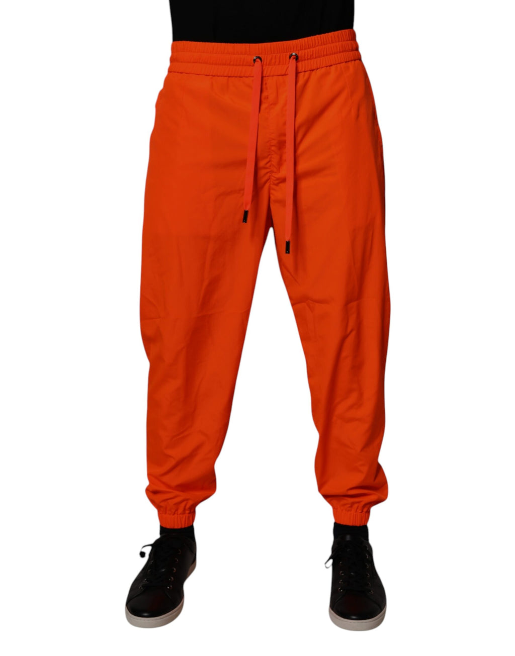 Pantalon jogging homme en polyester orange Dolce & Gabbana, coupe décontractée avec ceinture élastique et poches latérales.