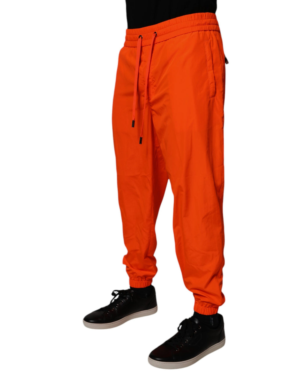 Pantalon jogging homme Dolce & Gabbana en polyester orange avec ceinture élastique et poches latérales.