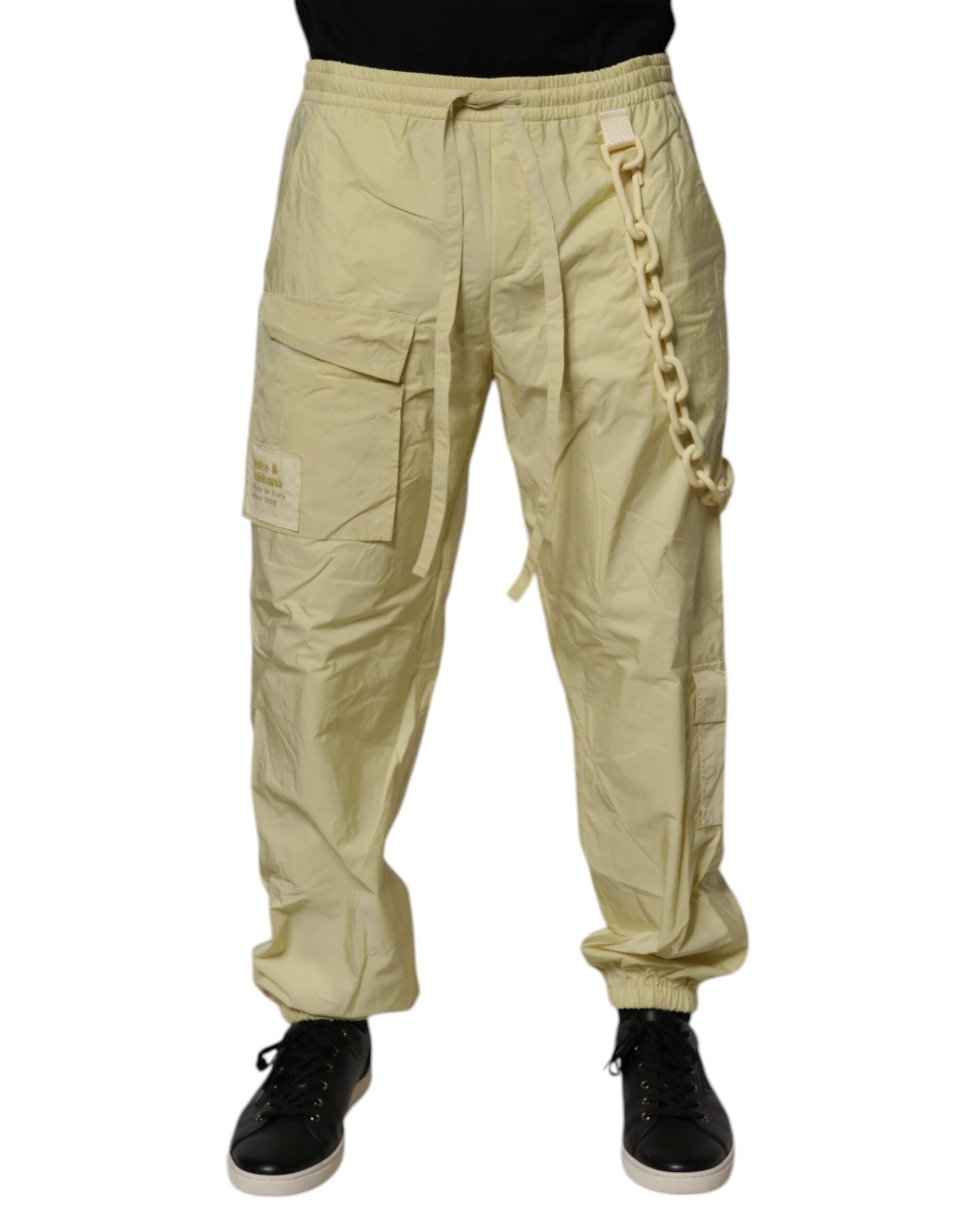 Pantalons joggers homme Dolce & Gabbana en nylon jaune avec chaîne cargo, style décontracté et détails modernes.