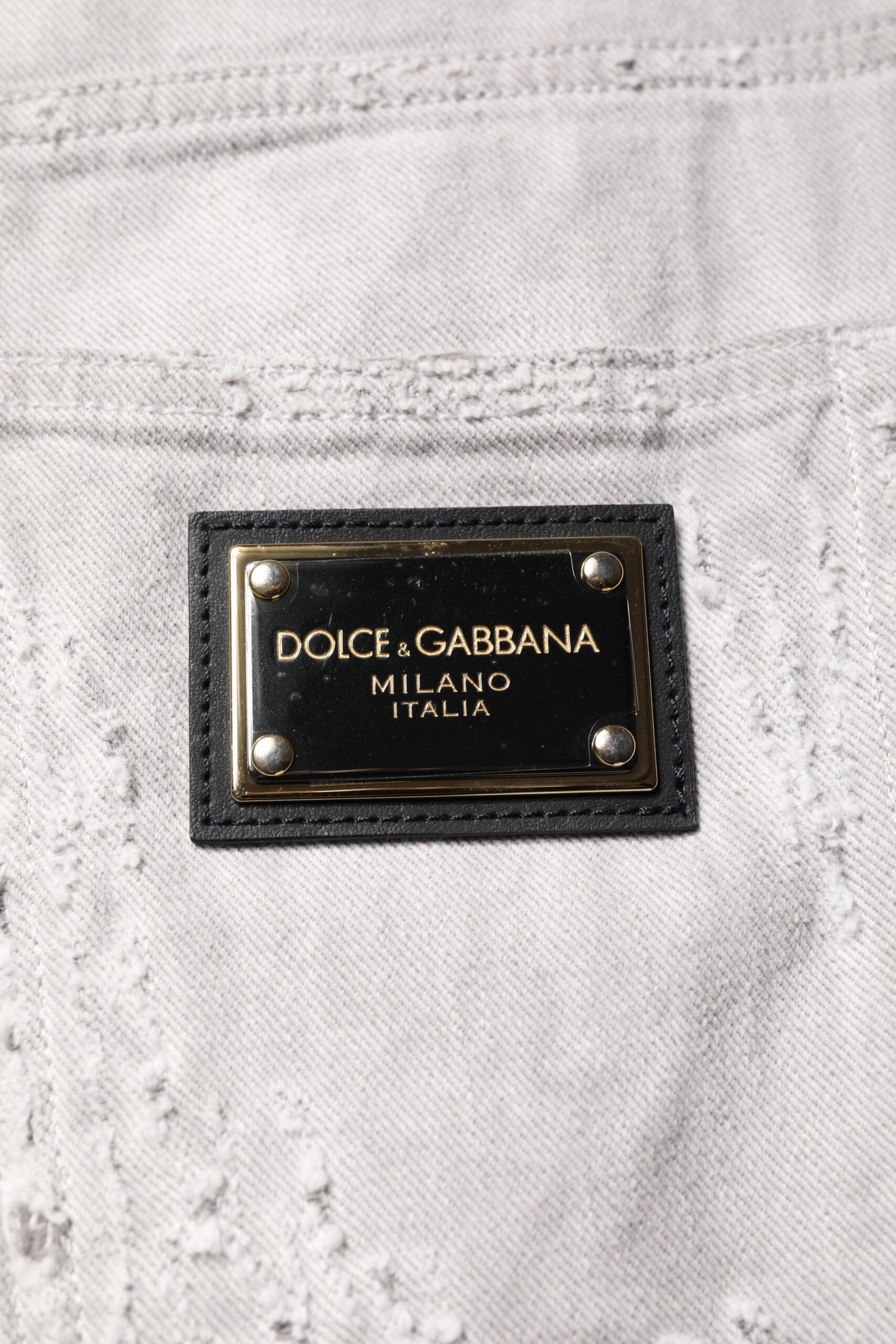 Shorts bermuda en jean gris clair déchiré pour homme de la marque Dolce & Gabbana, style décontracté et tendance.