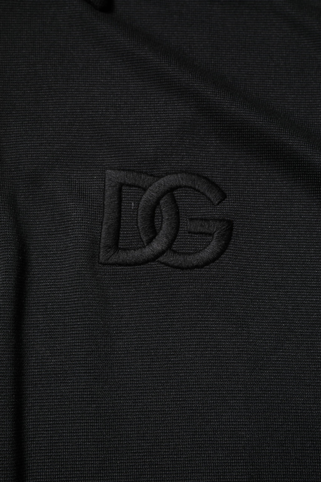 T-shirt polo noir en polyester Dolce & Gabbana avec logo DG, col classique, tissu élégant et moderne.