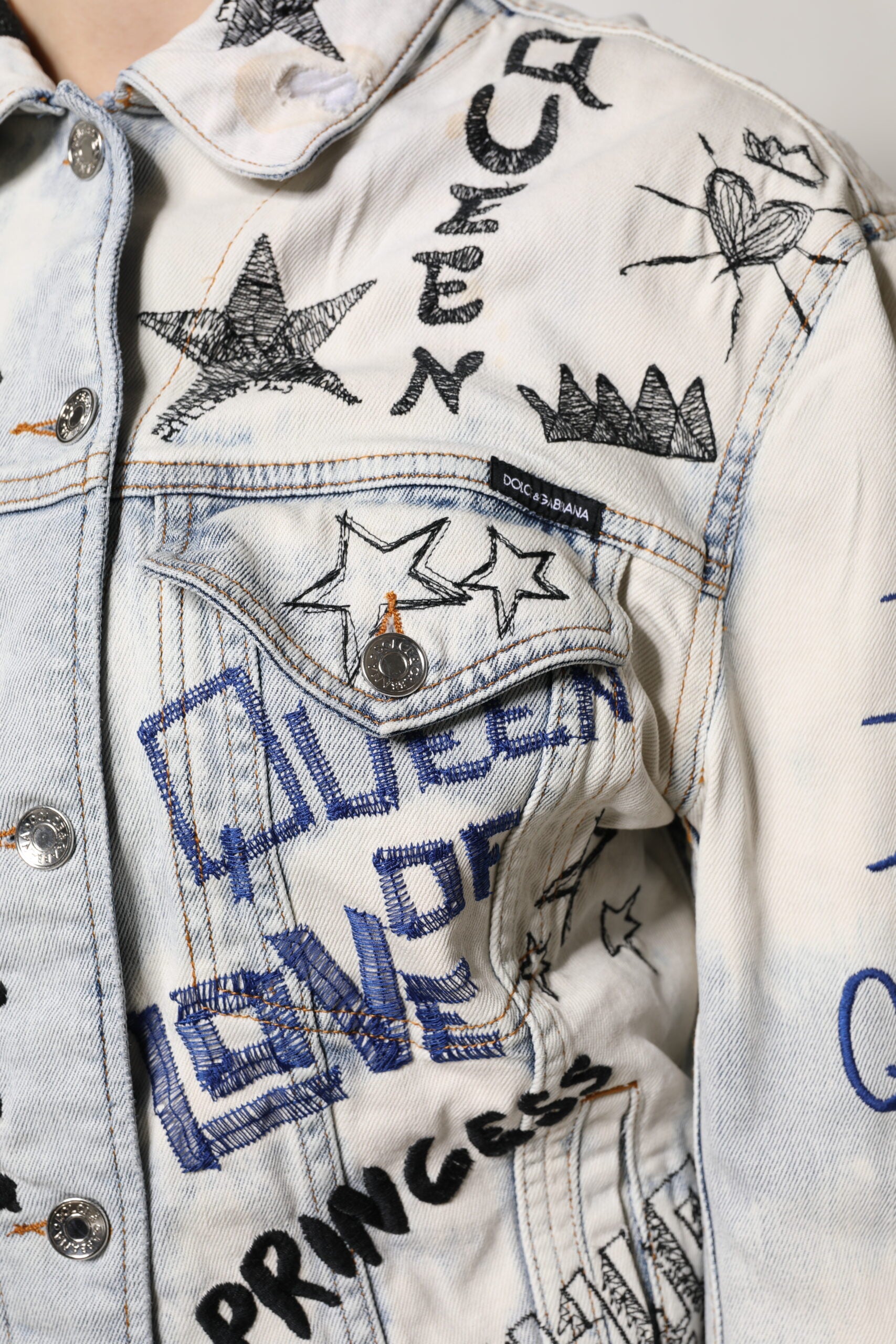 Veste en jean Dolce & Gabbana Light Blue Graffiti avec boutons, décontractée et tendance, visible en gros plan.