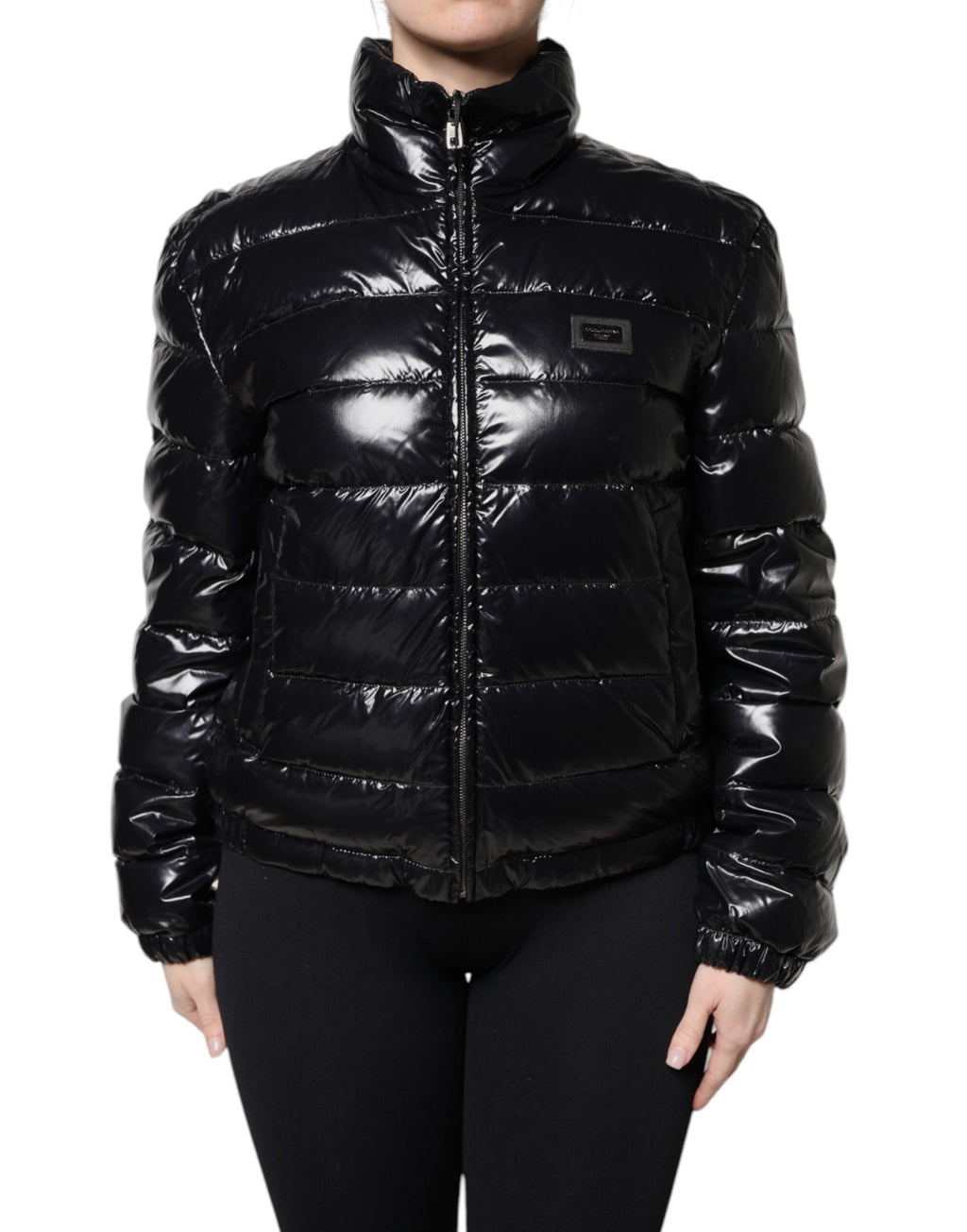 Veste matelassée noire Dolce & Gabbana avec logo en plaque, fermeture éclair complète et style élégant.