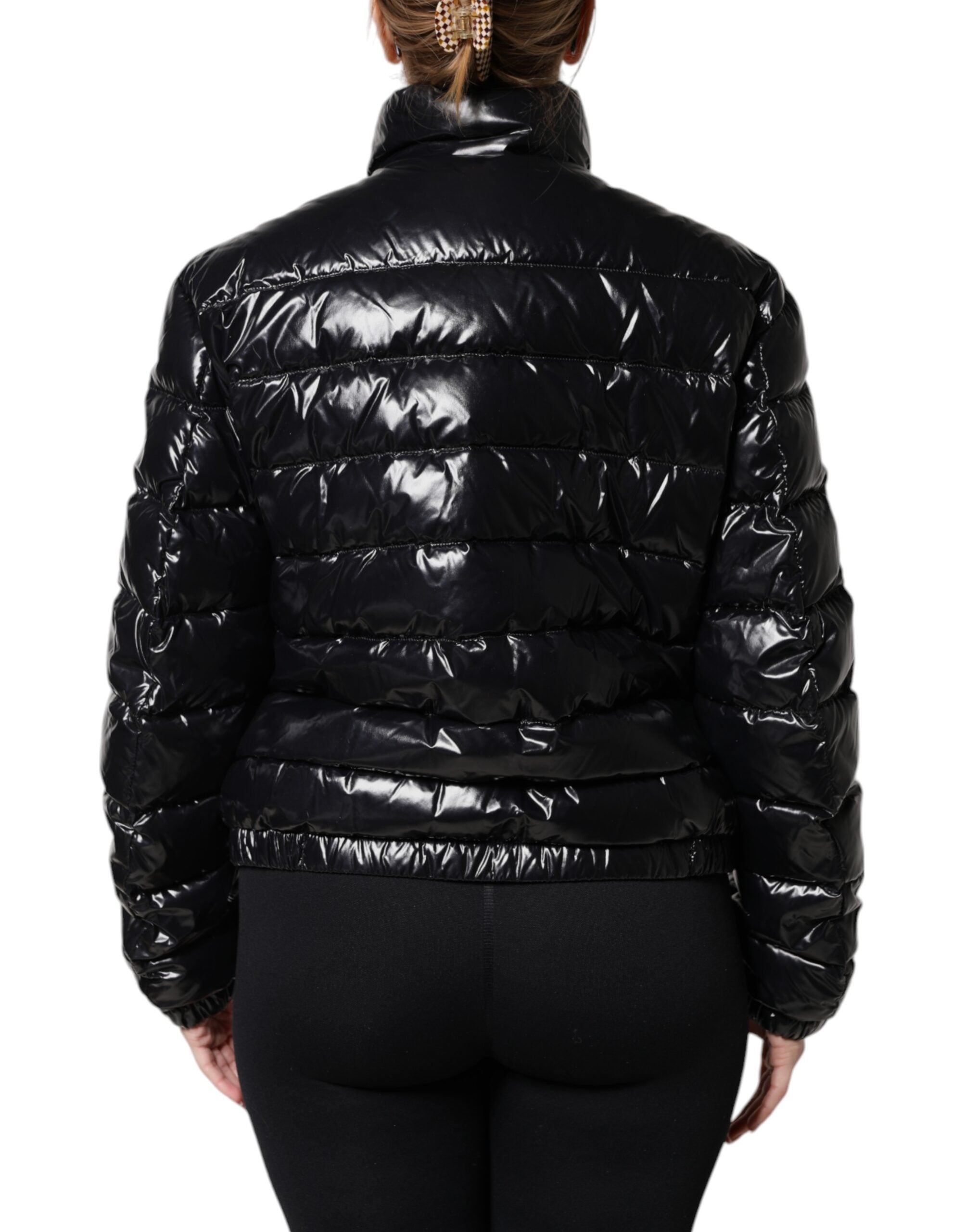 Veste matelassée noire Dolce & Gabbana avec logo en plaque, fermeture éclair intégrale, style chaud et tendance.