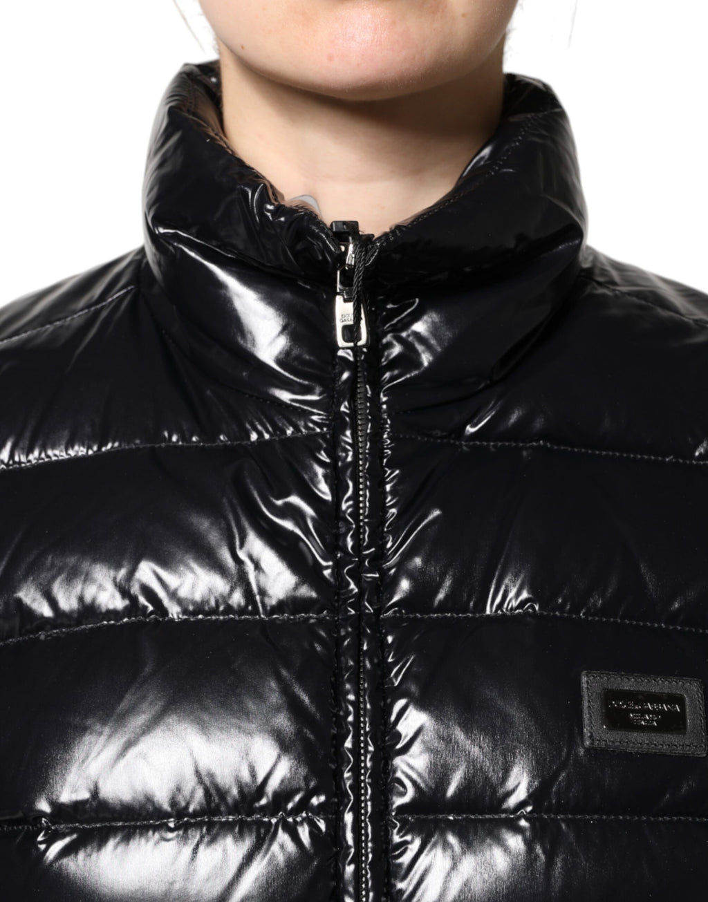 Veste matelassée noire Dolce & Gabbana avec logo en plaque, fermeture éclair complète, style chaud et tendance.