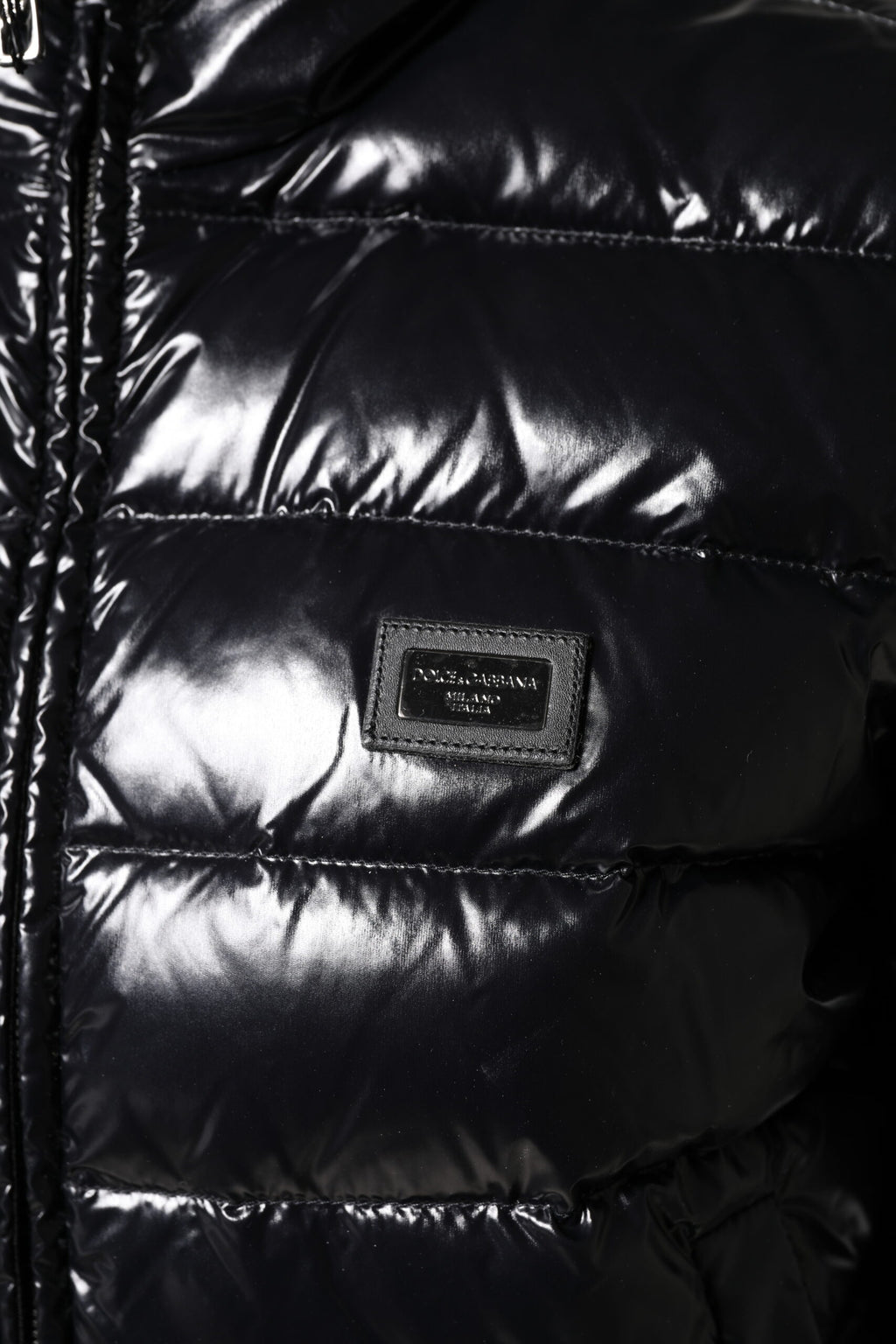 Veste matelassée noire Dolce & Gabbana avec logo en plaque, zip complet, style chaud et élégant.
