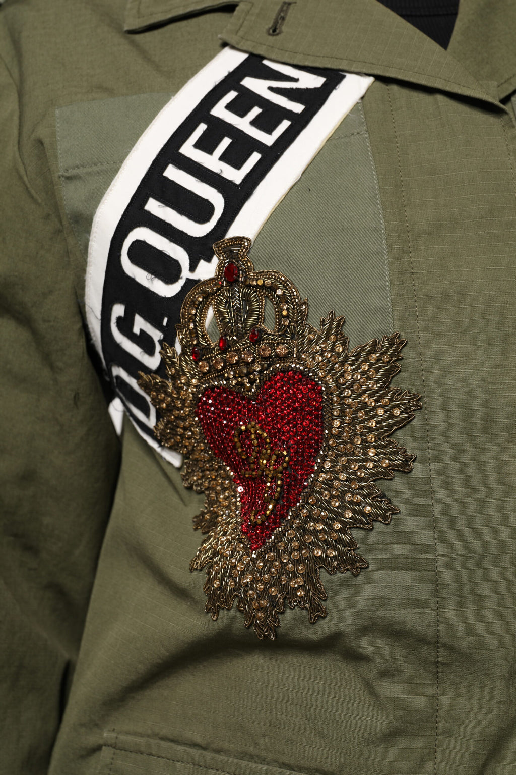 Manteau militaire vert olive Dolce & Gabbana pour femme avec embellissements élégants et détails sophistiqués.