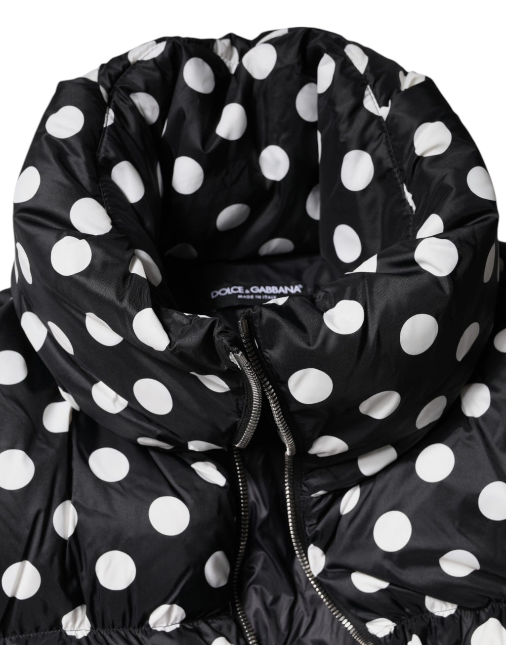 Doudoune Dolce & Gabbana noire et blanche à pois, zippée complète, rembourrée, avec capuche et design élégant.