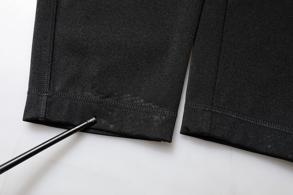 Pantalon noir en nylon à taille haute, coupe slim, de la marque Dolce & Gabbana, visible en image.