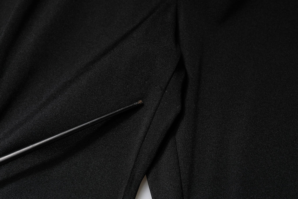 Pantalons noirs en nylon à taille haute et coupe slim de Dolce & Gabbana, vue de face sur fond blanc.