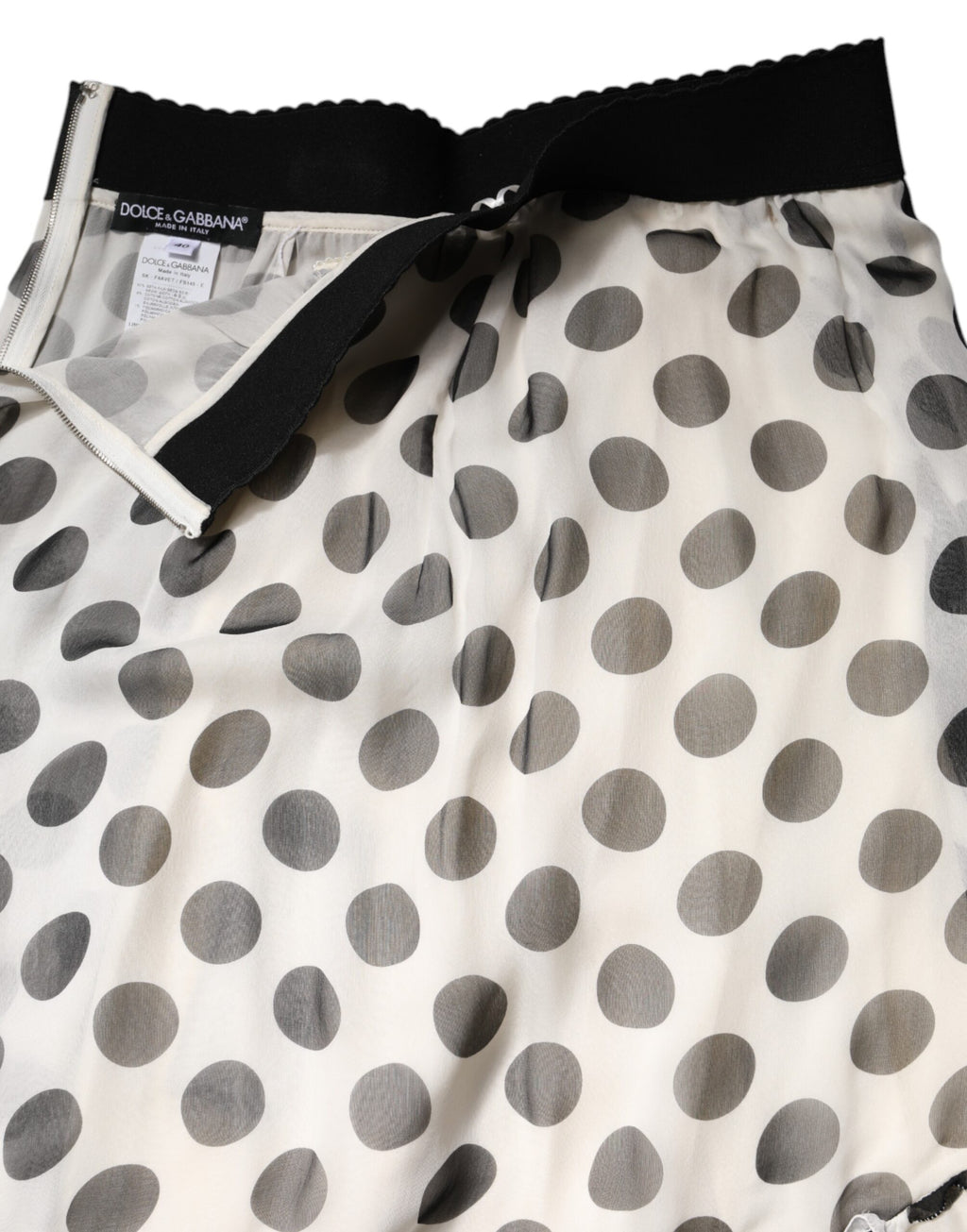 Jupe longue à pois noir et blanc de Dolce & Gabbana, longueur au genou, style élégant et sophistiqué.