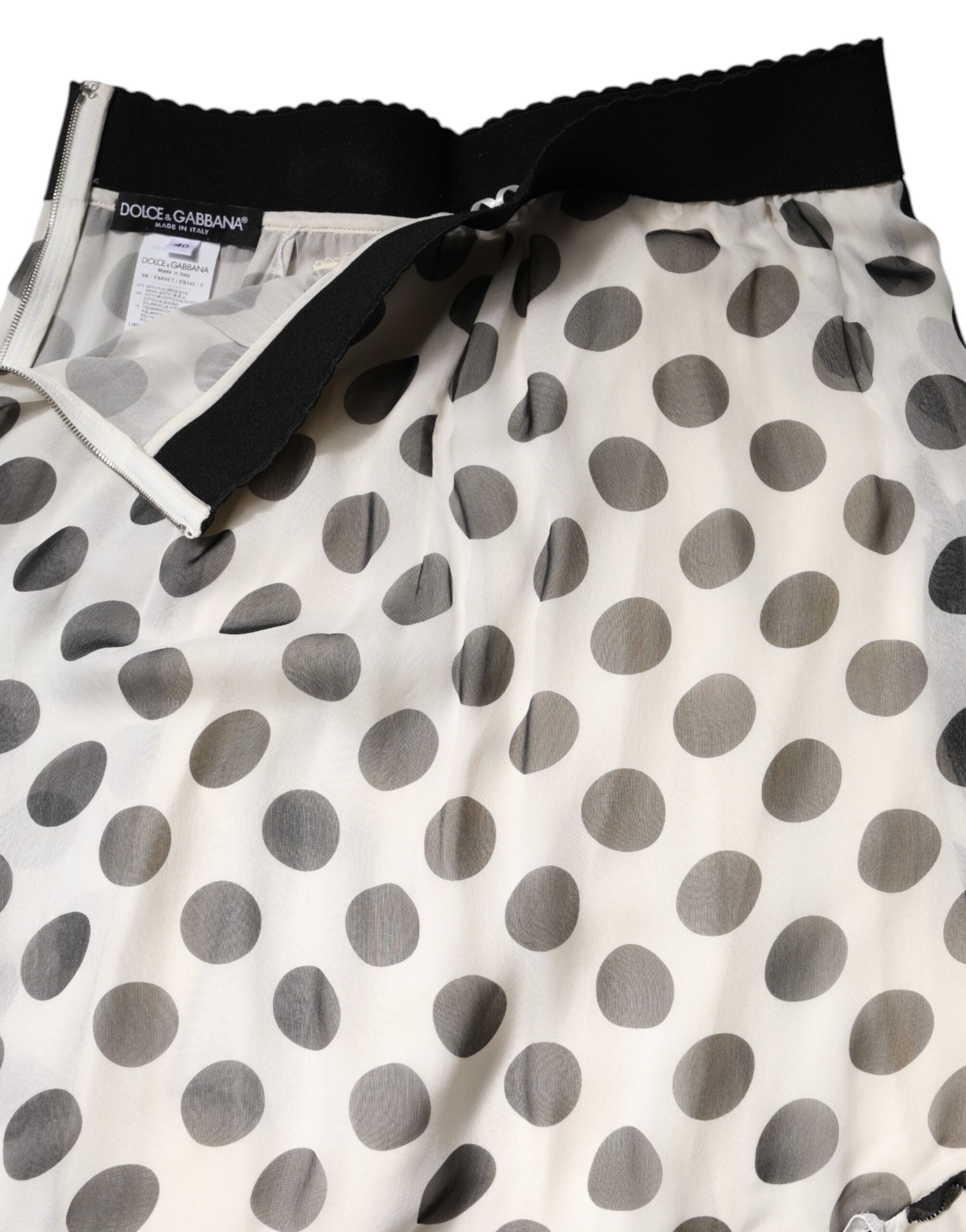 Jupe longue à pois noir et blanc de Dolce & Gabbana, longueur au genou, style élégant et sophistiqué.