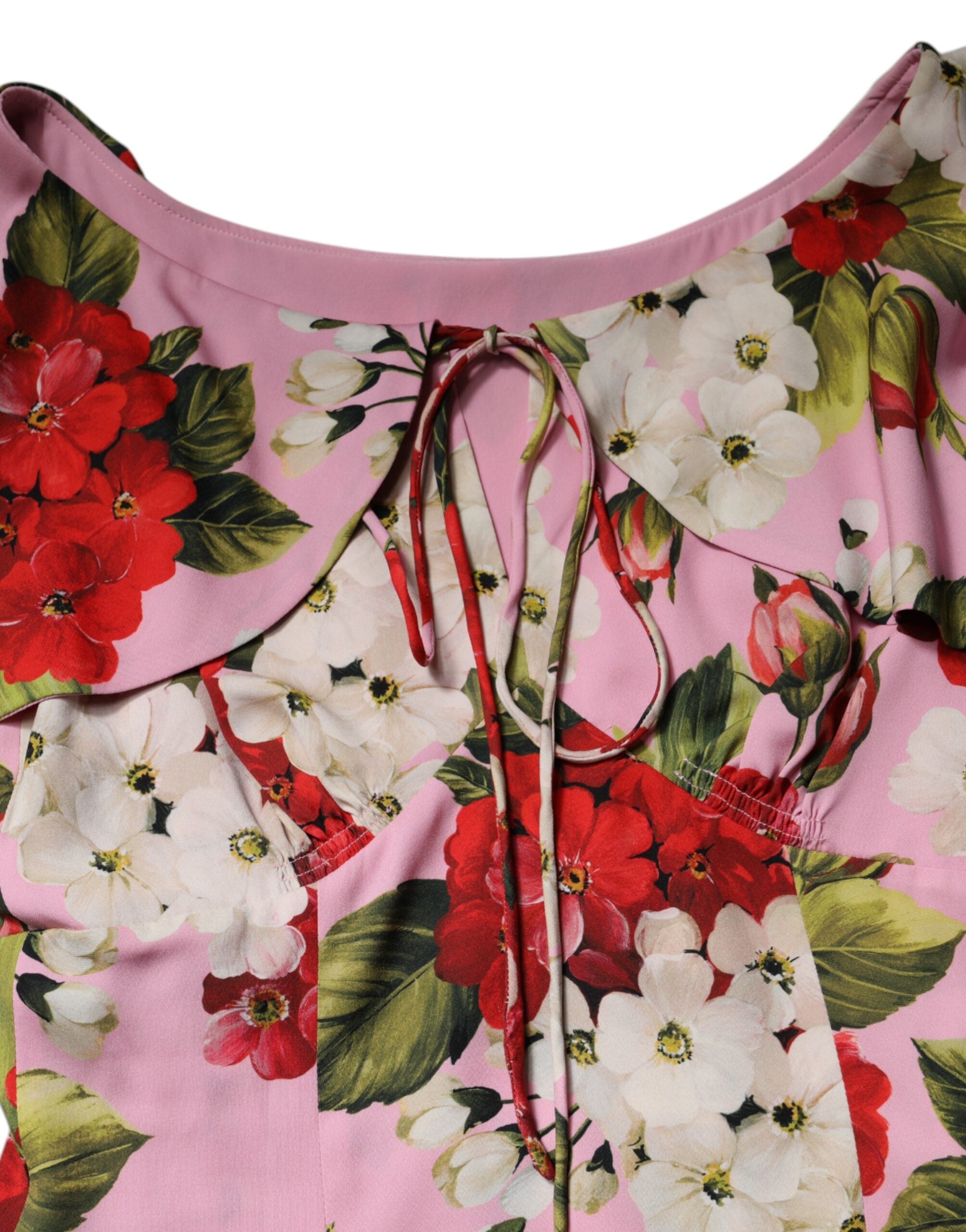 Blouse en soie rose à fleurs Dolce & Gabbana avec manches courtes, élégante et féminine, portée en haut de la robe.