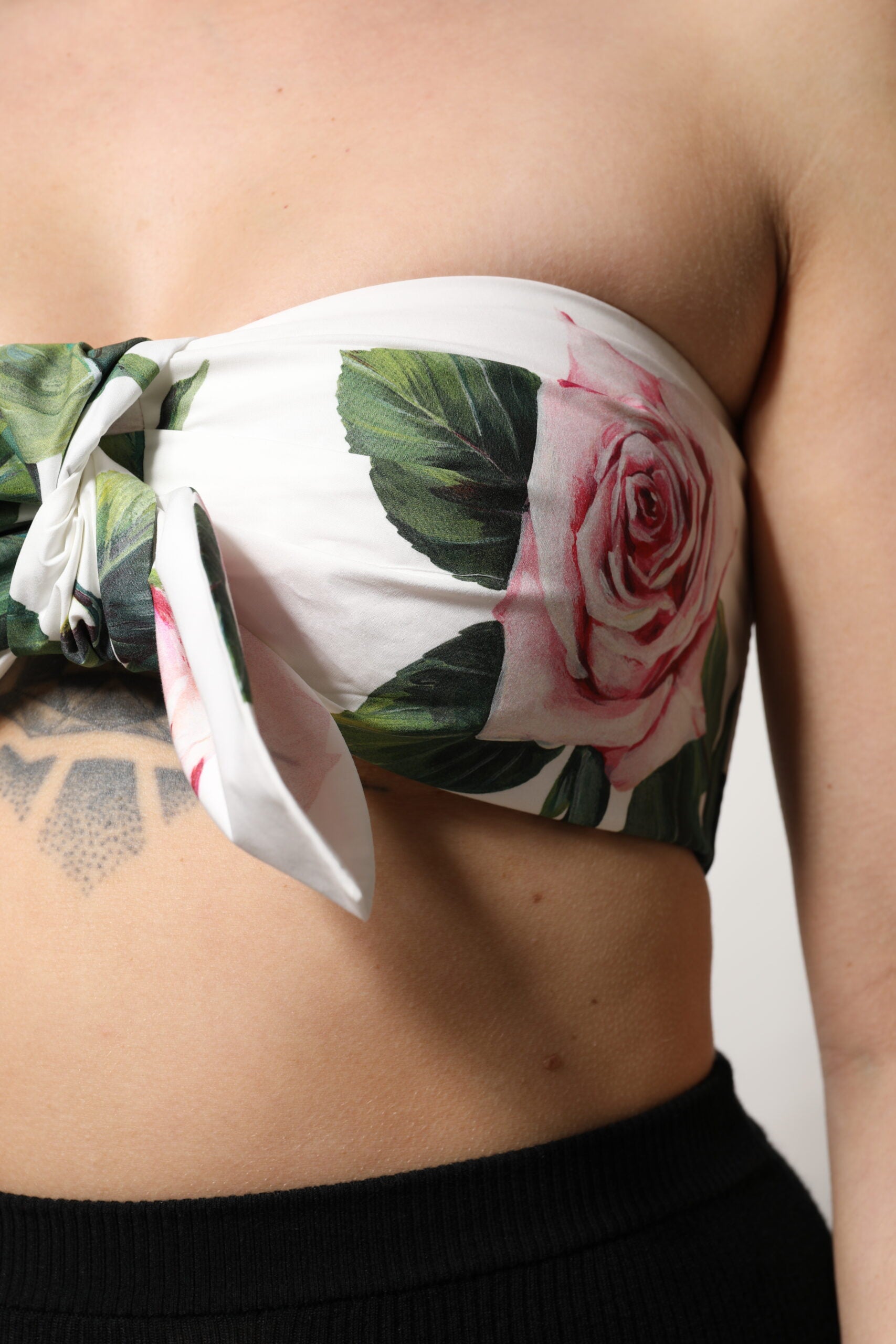 Corset cropped blanc avec imprimé floral Dolce & Gabbana, ajusté et élégamment conçu, visible en détail dans l'image.