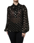 Blouse noire en dentelle transparente Dolce & Gabbana avec col noué à pois noirs et blancs, style élégant et féminin.