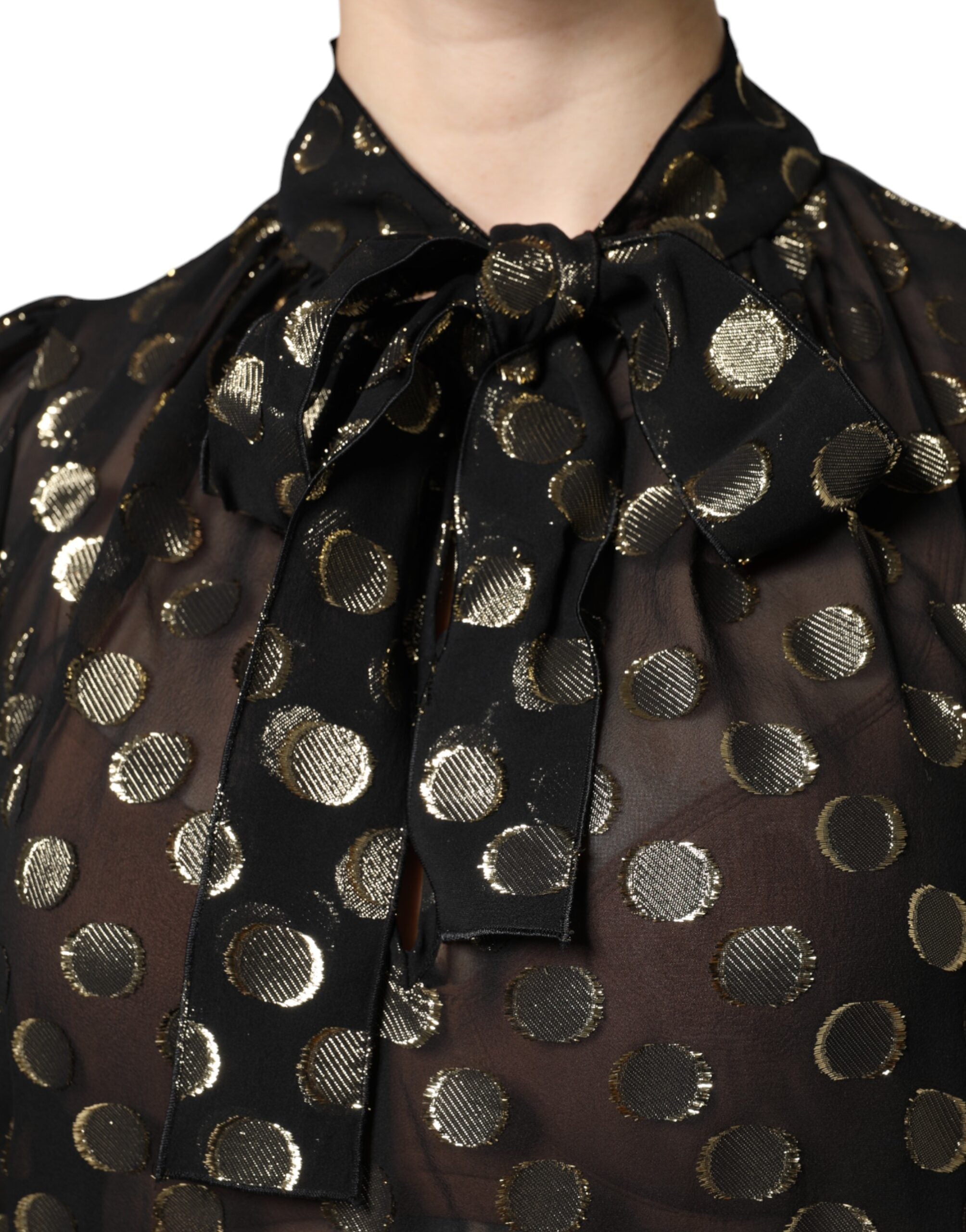 Chemise noire Dolce & Gabbana en tissu transparent avec noeud au col et motif à pois, élégante et légère.