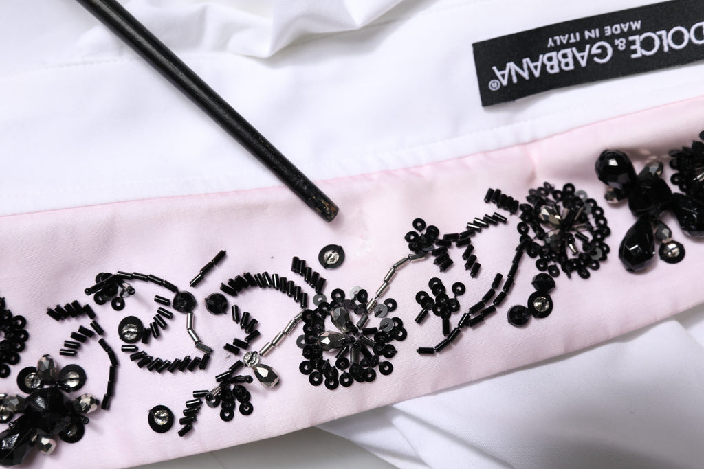 Chemise blanche Dolce & Gabbana avec col et embellissements, tenue élégante en tissu léger.