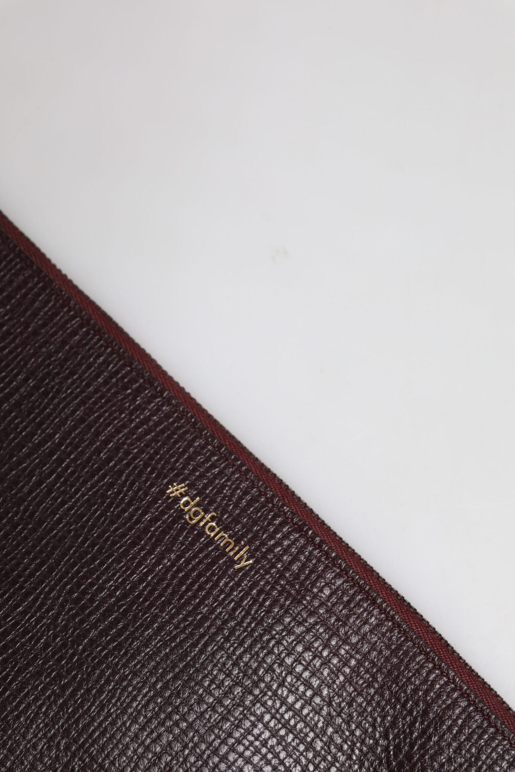 Pochette pour homme Dolce & Gabbana en cuir marron avec embellissements, sac à main élégant et compact.